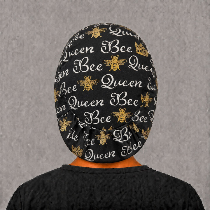 Back view of the Queen Bee Euro scrub cap — elastic gathered back showing gold bees and crowns across the black crown
