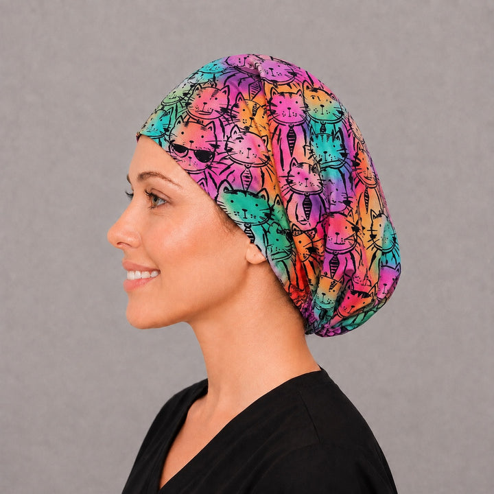 Woman wearing a rainbow cat Euro scrub cap, front view — colorful tie-dye kitty faces, adjustable surgical hat for women nurses