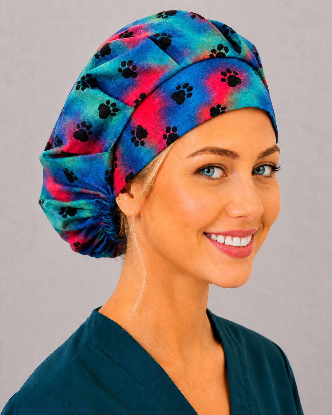 Rainbow paw bouffant surgical cap for long hair, right angled view — deep gathered fit that secures thick or voluminous hair