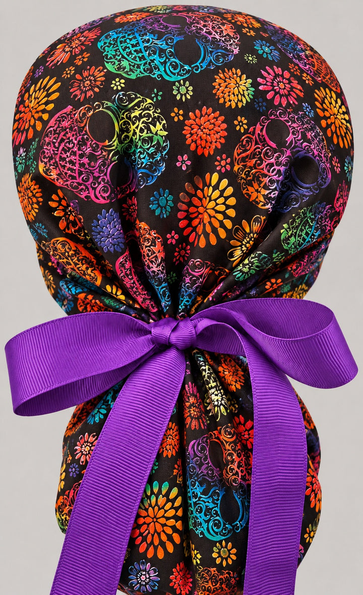 Back of the rainbow skull ponytail scrub cap showing the adjustable purple grosgrain bow tie
