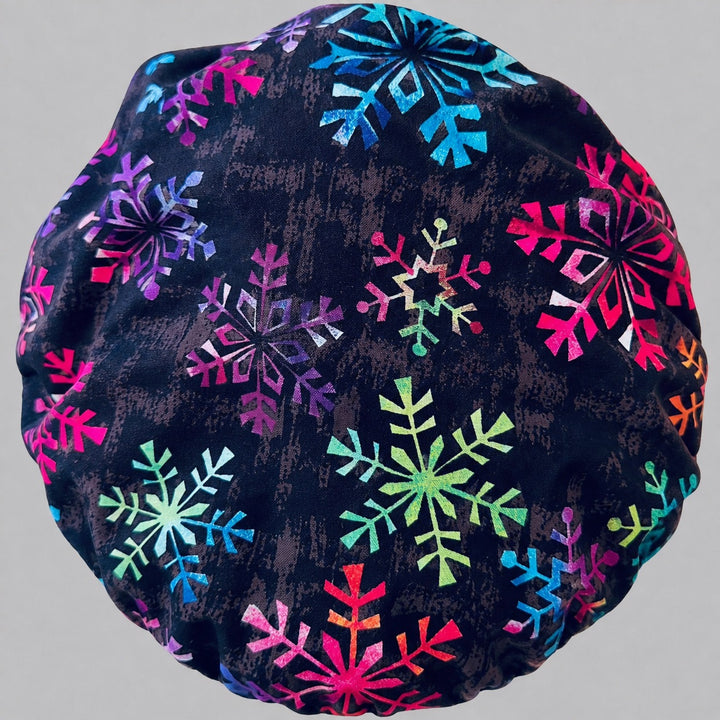 Back view of the rainbow snowflake bouffant scrub cap — full gathered fit showing colorful snowflakes across the black crown