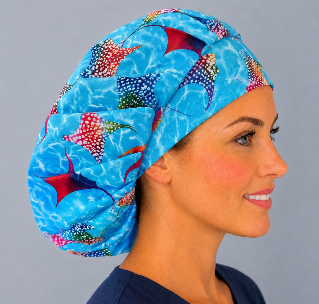 Side view of the rainbow stingray bouffant surgical hat — colorful manta rays on blue water, roomy breathable cotton cap for ocean-loving nurses