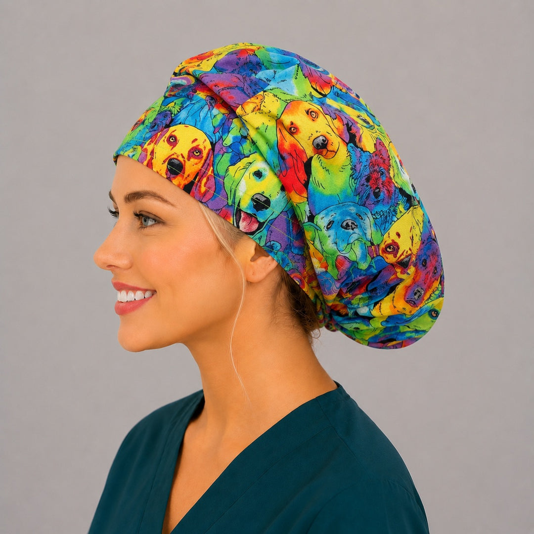 Rainbow watercolor dog bouffant scrub cap left three-quarter angle on smiling model showing colorful puppy portraits in rainbow watercolor, women&