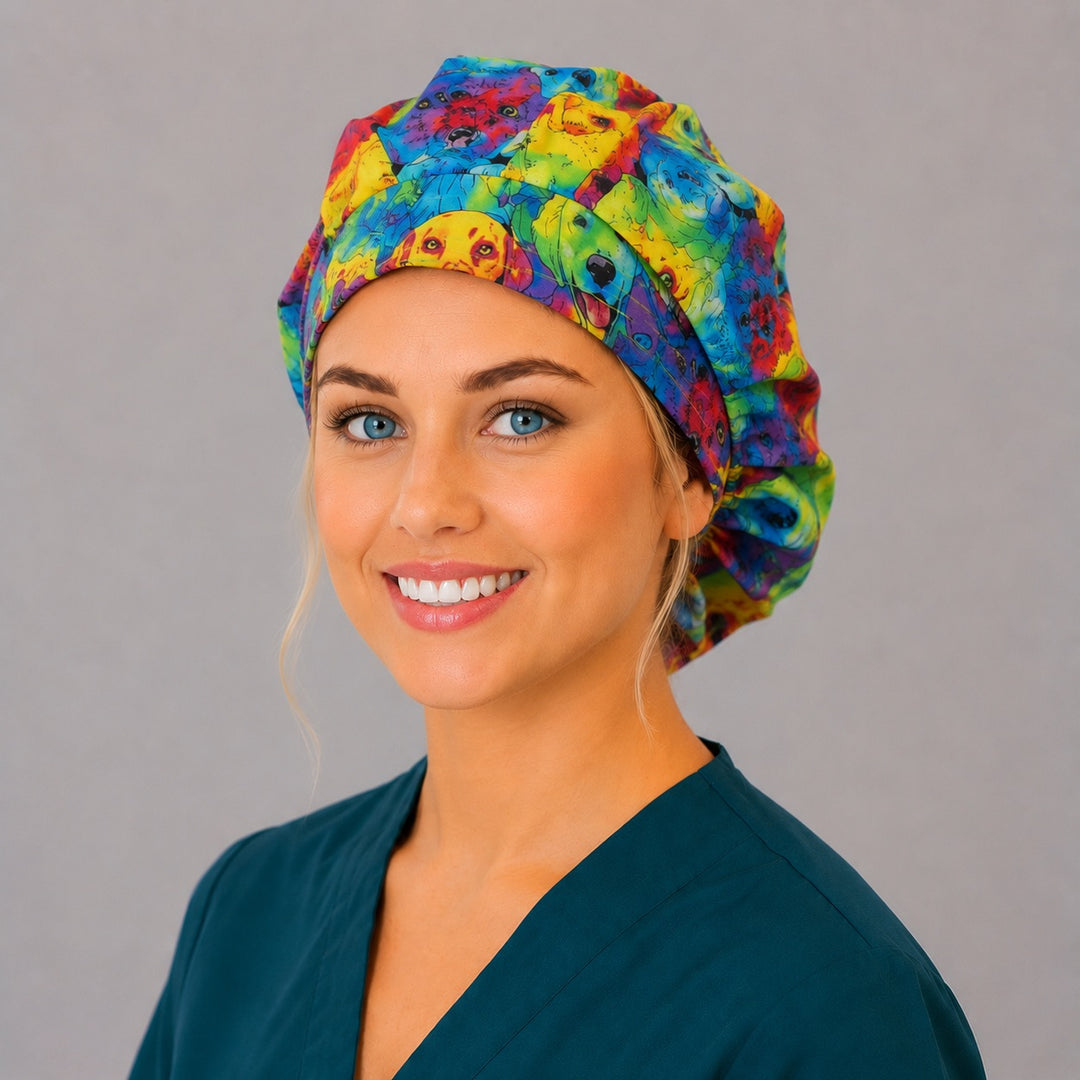 Rainbow watercolor dog bouffant scrub cap right three-quarter angle on smiling model showing colorful dog portraits in rainbow watercolor, women's veterinary surgical hat OR World