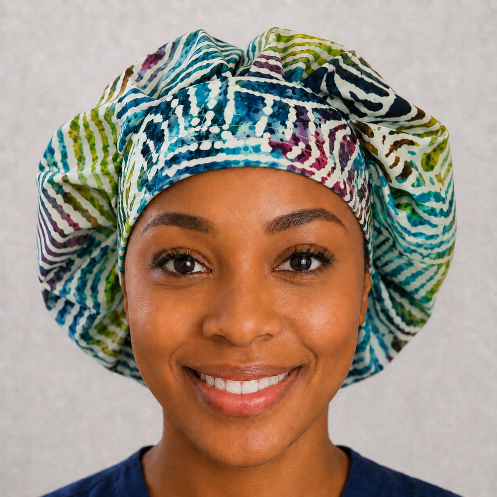 Woman wearing a rainbow zebra print bouffant scrub cap, front view — watercolor batik stripes in teal, green and magenta, adjustable women's surgical hat