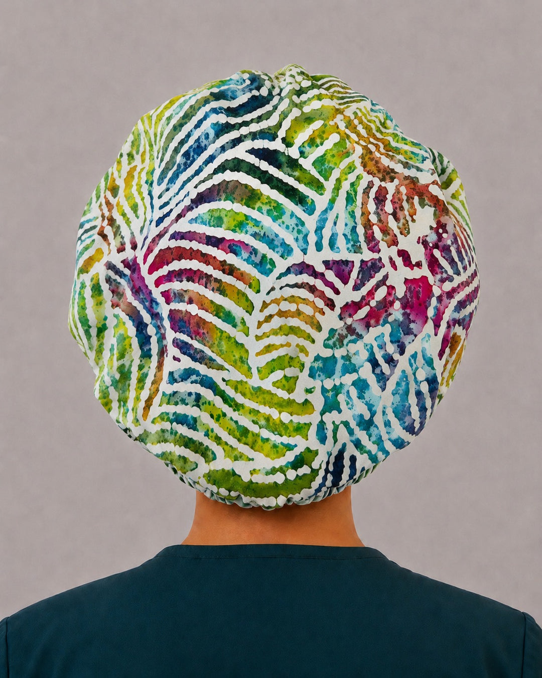 Back view of the rainbow zebra bouffant scrub cap — full gathered fit showing watercolor batik stripes across the crown