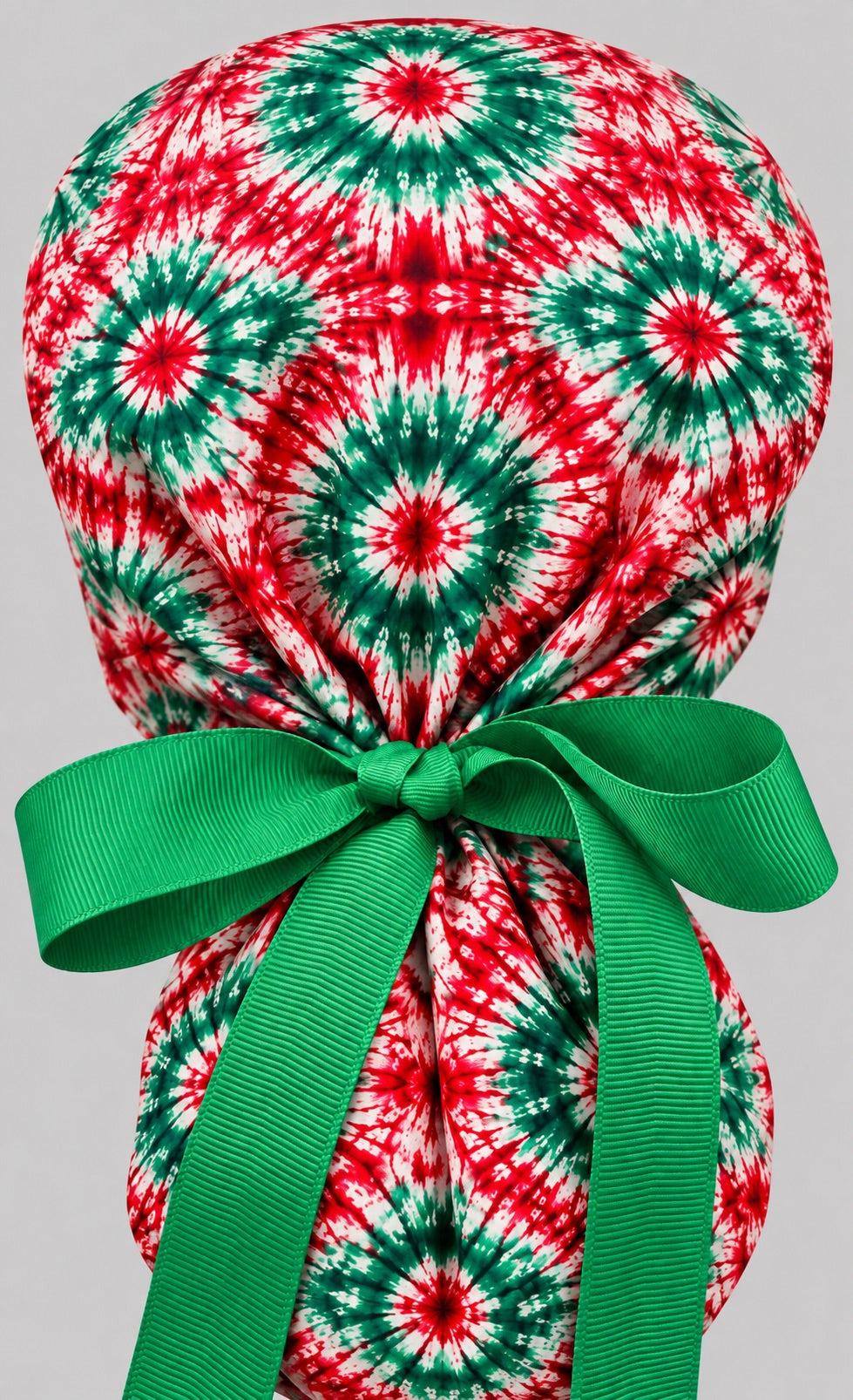Back of the red and green tie-dye ponytail cap showing the adjustable green grosgrain bow tie