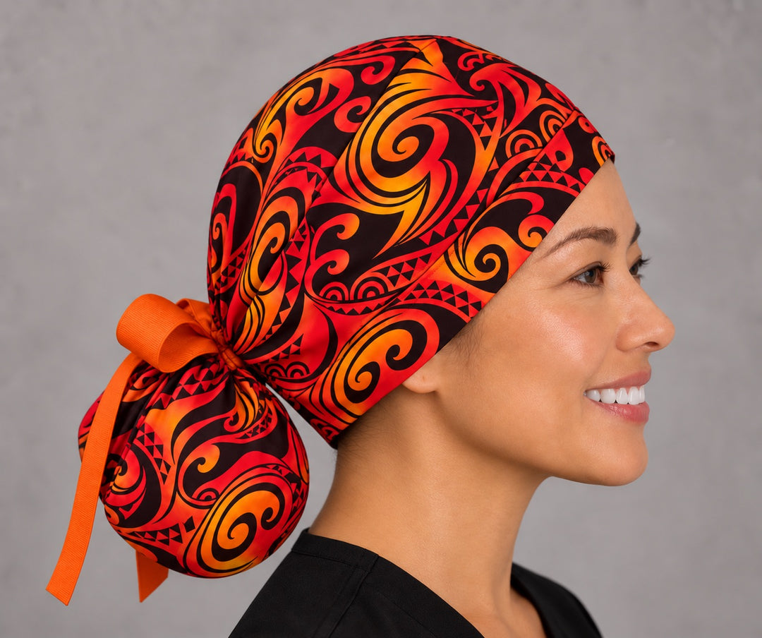 Red and orange tribal ponytail cap, left side profile — handmade Polynesian flame print surgical cap, USA made