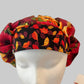 Top view of red & gold sunflower fall bouffant scrub cap fabric — handmade USA autumn surgical hat for OR nurses with room for long hair.