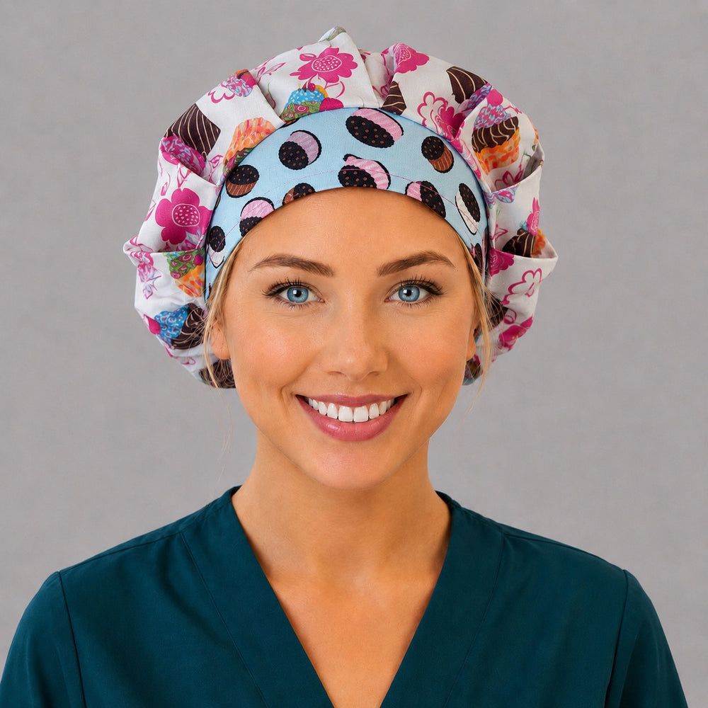 Woman wearing a retro cupcake bouffant scrub cap, front view — pink floral cupcake print with blue ice cream sandwich band, adjustable women's surgical hat