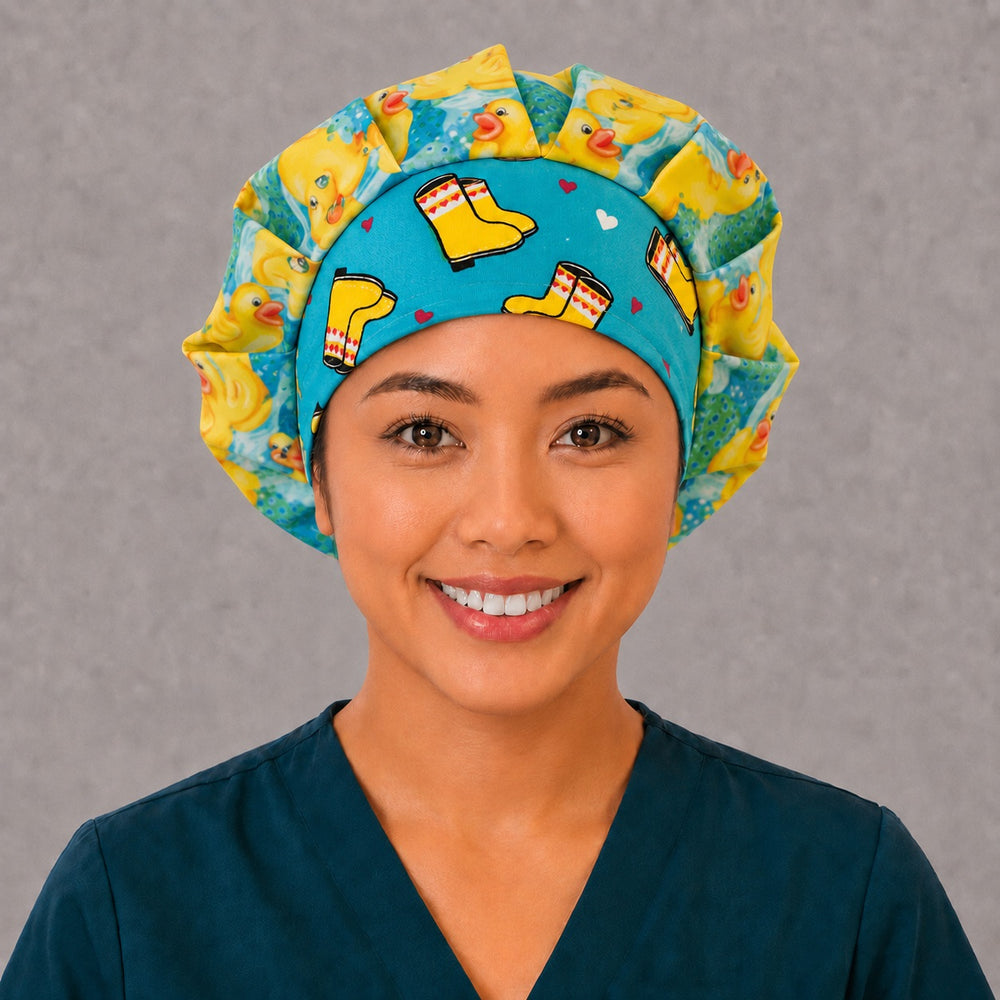 Woman wearing a rubber duckies bouffant scrub cap, front view — yellow ducks on aqua with a yellow rain boot band, adjustable women's surgical hat