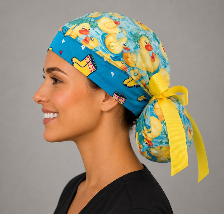 Rubber duckies rain boots ponytail scrub cap right side profile with full ponytail pouch of yellow ducks and long yellow ribbon ties