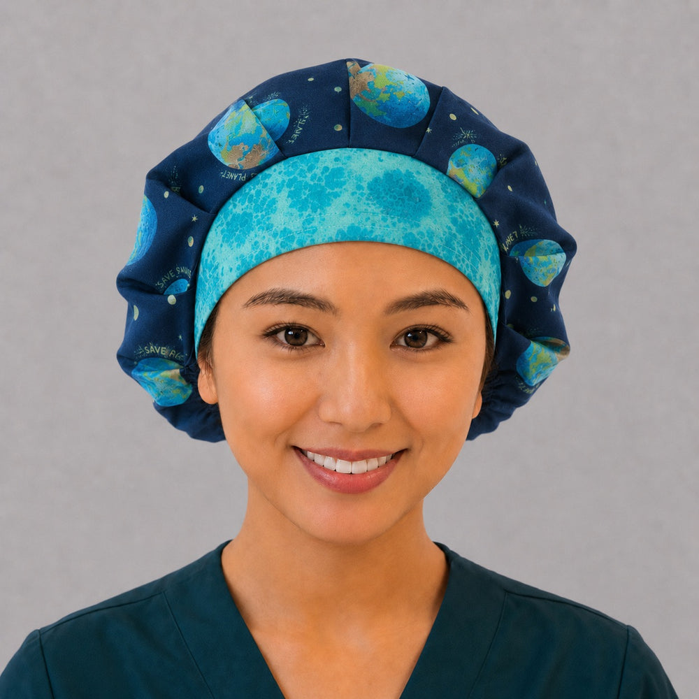 Woman wearing a Save the Planet bouffant scrub cap, front view — navy earth and tree print with turquoise band, adjustable unisex surgical hat