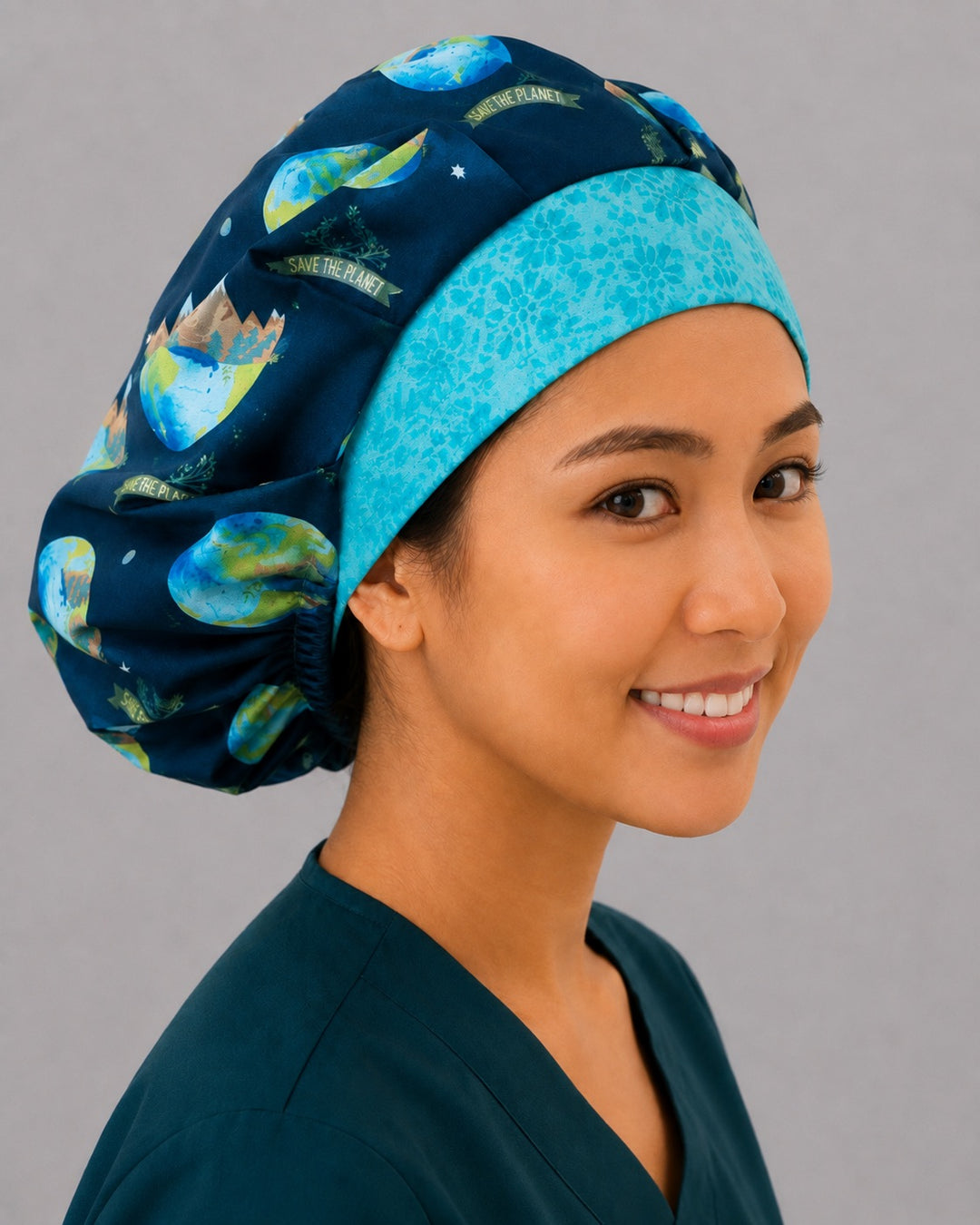 Save the Planet earth bouffant scrub cap, angled smiling view — roomy elastic-back cap that secures long thick hair for OR nurses