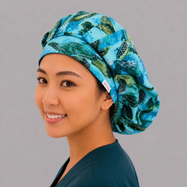 Sea turtle bouffant scrub cap left side profile showing green sea turtles swimming through blue coral reef, women&