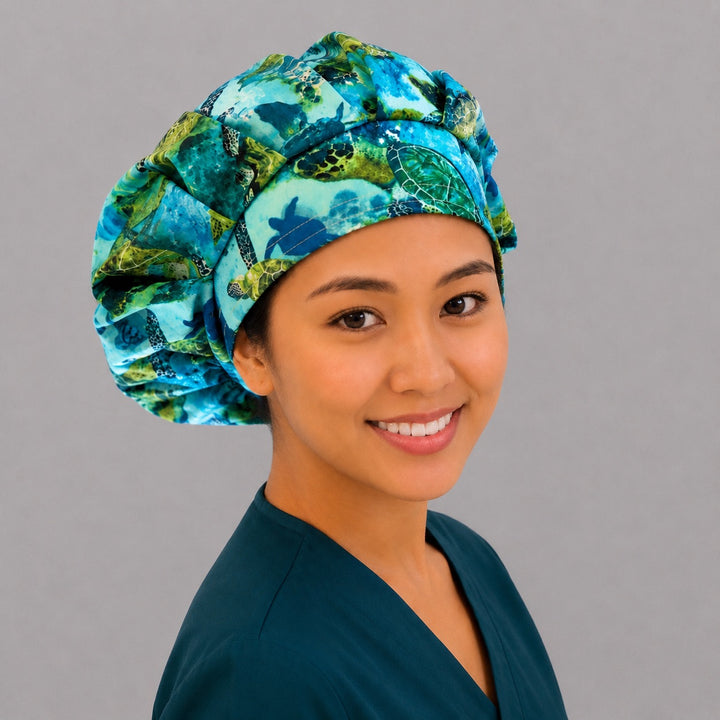 Sea turtle bouffant scrub cap left three-quarter angle on smiling model showing green sea turtles swimming in blue ocean, women&