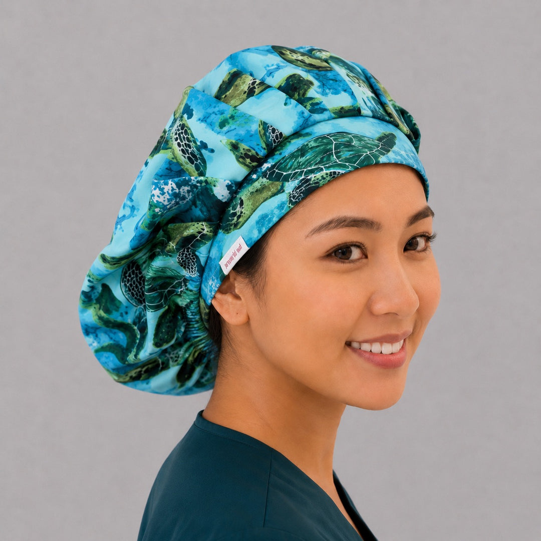 Sea turtle bouffant scrub cap right side profile showing green sea turtles and coral reef band on teal ocean, OR World marine-life nurse hat