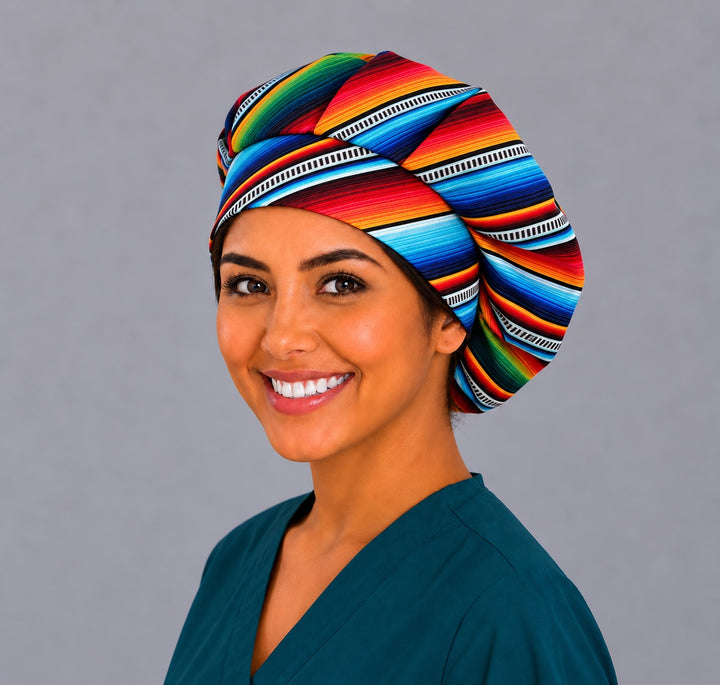 Left three-quarter view of a rainbow serape bouffant scrub cap on a smiling nurse, roomy Mexican surgical hat for women with long hair
