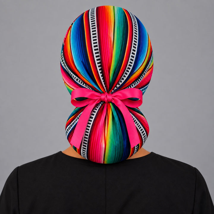 Back of a Mexican serape ponytail scrub cap showing the ponytail pocket and pink ribbon tie