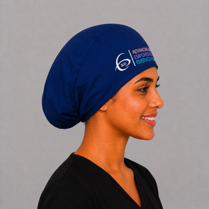 Side profile of the navy SGO official Euro scrub cap showing the elastic gathered back and embroidered Society of Gynecologic Oncology logo, a modern unisex fit for OR teams