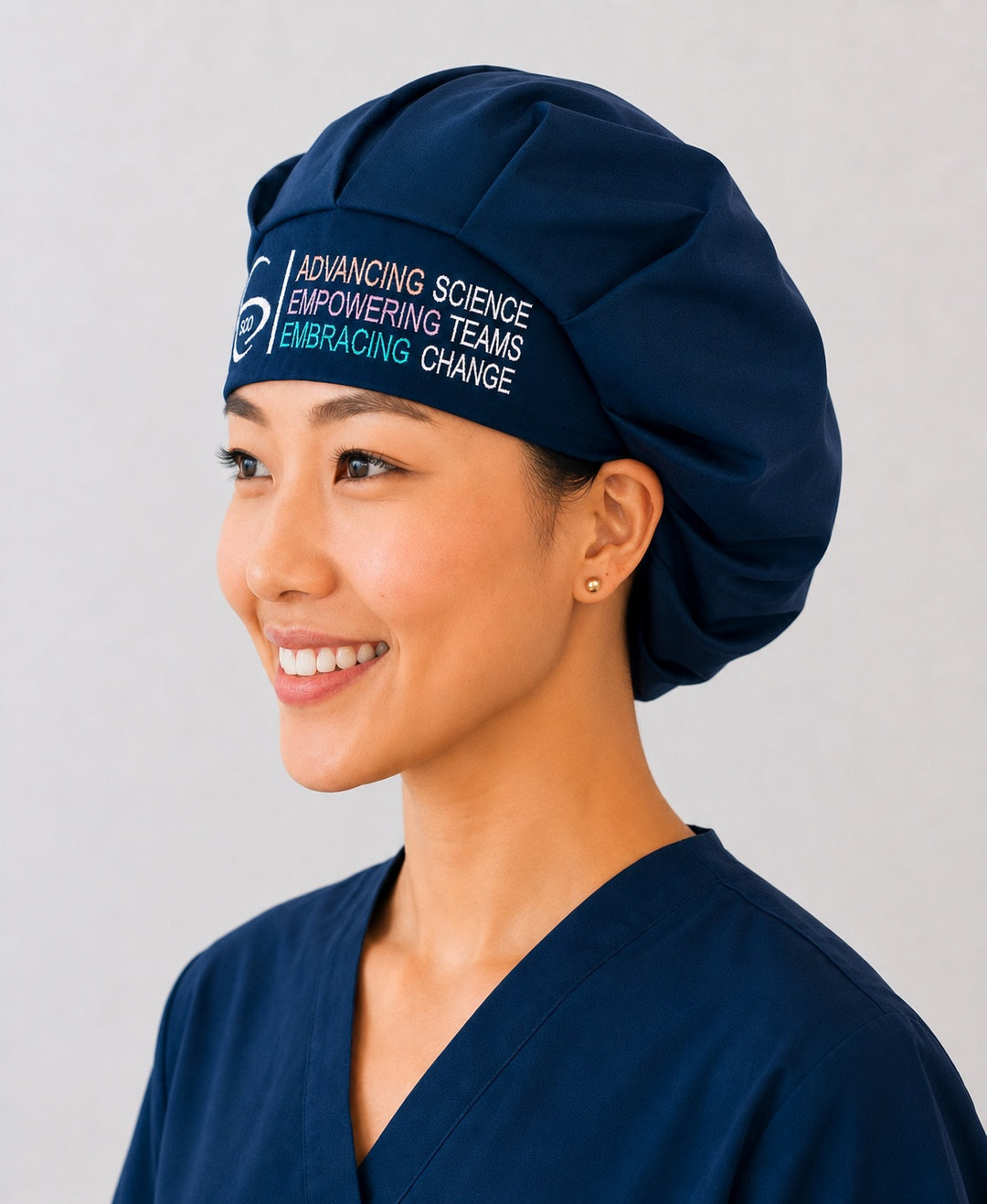 Side profile of the navy SGO official embroidered bouffant scrub cap showing the roomy bouffant crown and official logo