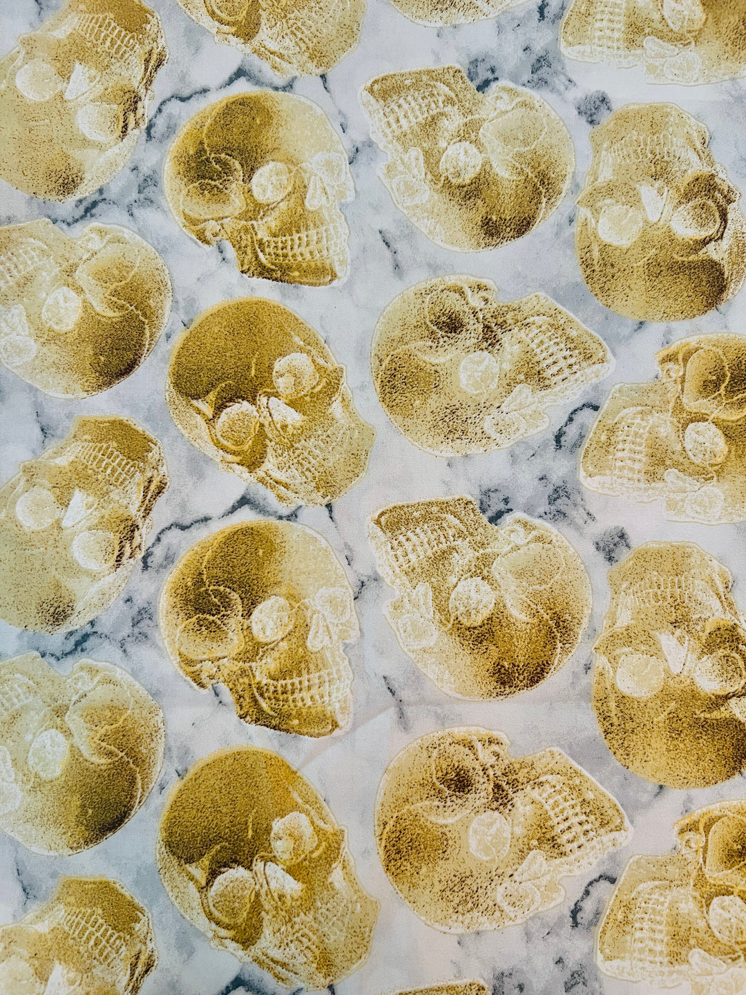 Close-up of neutral bone and gold skeleton skull print fabric on premium cotton scrub cap