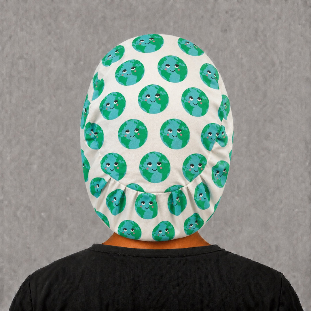 Back view of the smiling earth Euro scrub cap — full coverage showing kawaii globe faces across the crown