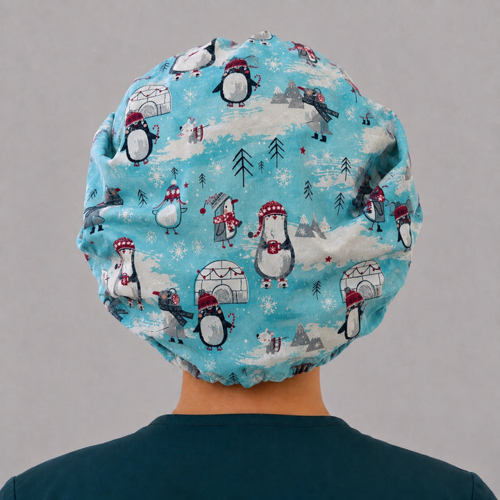 Snowflake band penguin bouffant scrub cap, left side profile — full deep fit that secures long thick hair for OR nurses