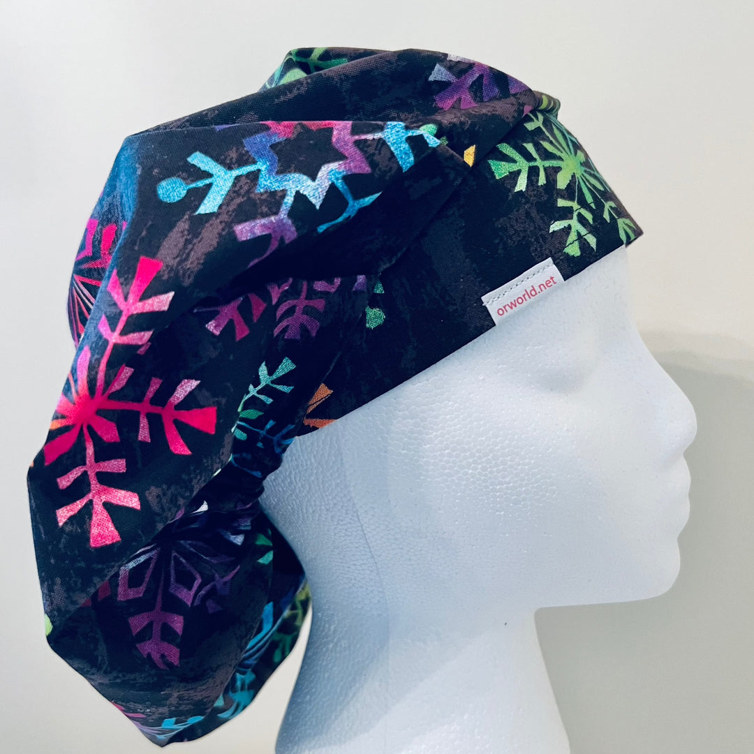 Top view of colorful snowflake bouffant scrub cap — handmade-in-USA holiday surgical hat, festive gift for nurses &amp; surgeons.