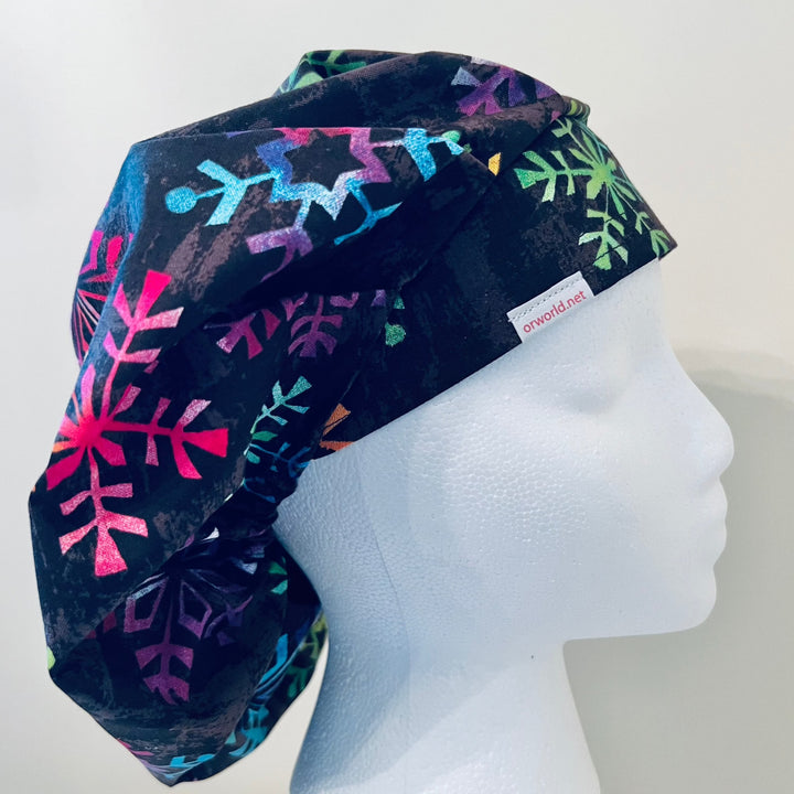 Top view of colorful snowflake bouffant scrub cap — handmade-in-USA holiday surgical hat, festive gift for nurses &amp; surgeons.