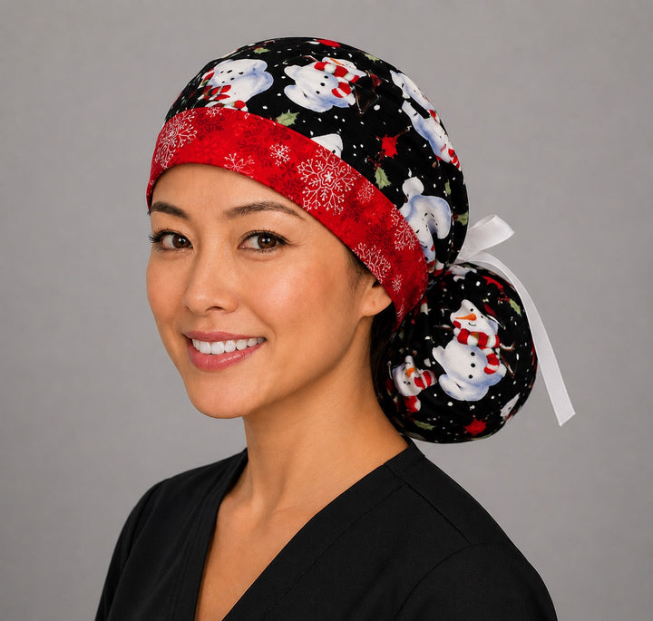 Snowmen ponytail scrub cap back view close-up showing gathered pouch full of snowmen in striped hats, cardinals and holly on black with white grosgrain ribbon bow