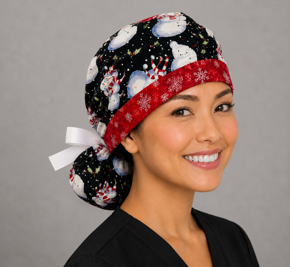 Snowmen ponytail surgical cap left side profile showing snowmen in striped hats and scarves on black with red snowflake band and white ribbon tie
