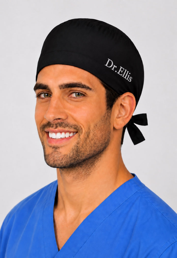Back view of solid black tie-back scrub cap showing the bow tie closure on a male model — handmade-in-USA men&