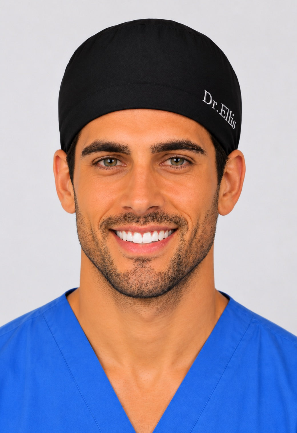 Black tie-back scrub cap with embroidered name "Dr. Ellis" on a male model, front view — personalized embroidery option, handmade-in-USA men&