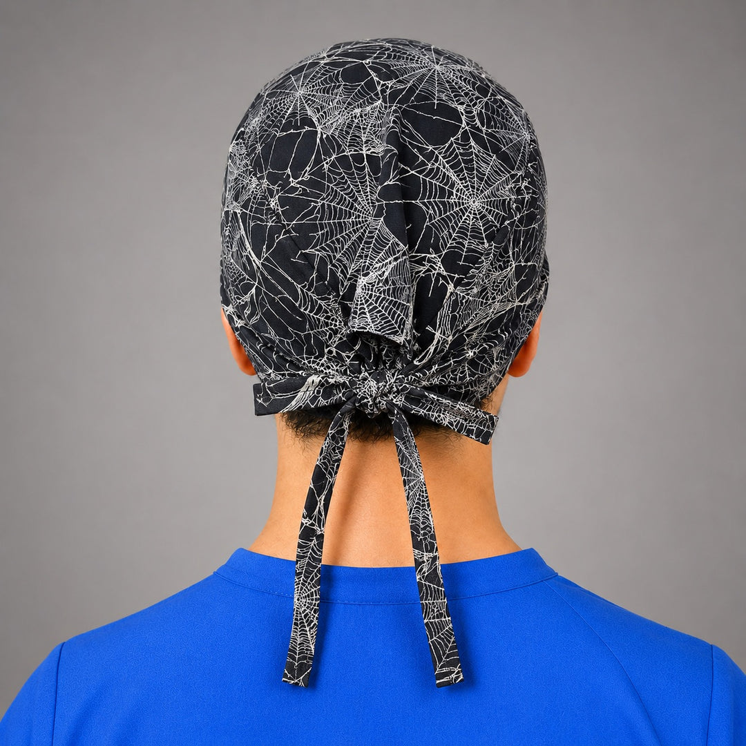 Spider web scrub cap for short hair, handmade black and white cobweb tie-back Halloween surgical hat on OR nurse, front view