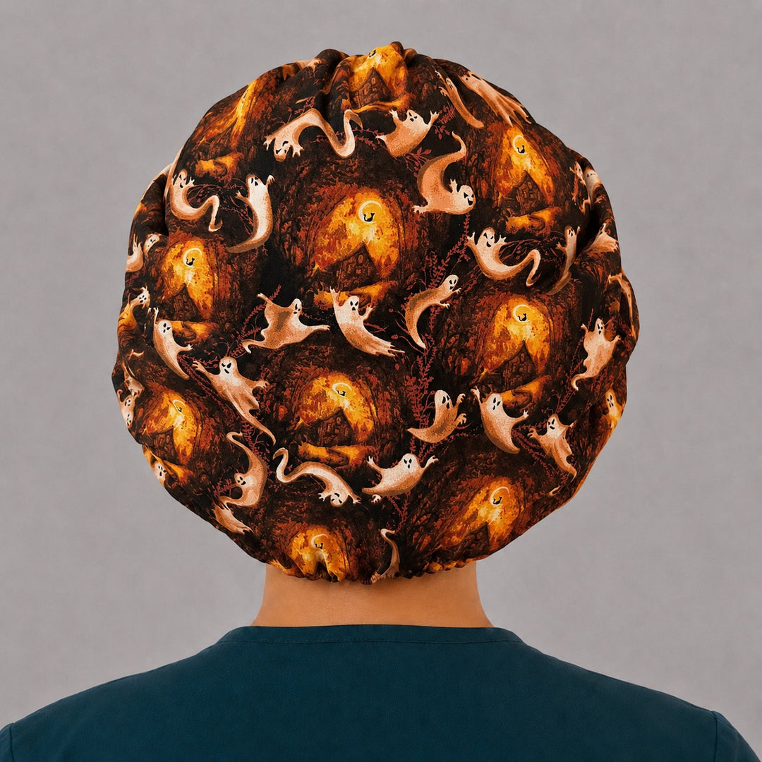 Right side profile of the spooky ghost bouffant surgical hat — burnt orange autumn woods and haunted houses, roomy breathable cotton cap