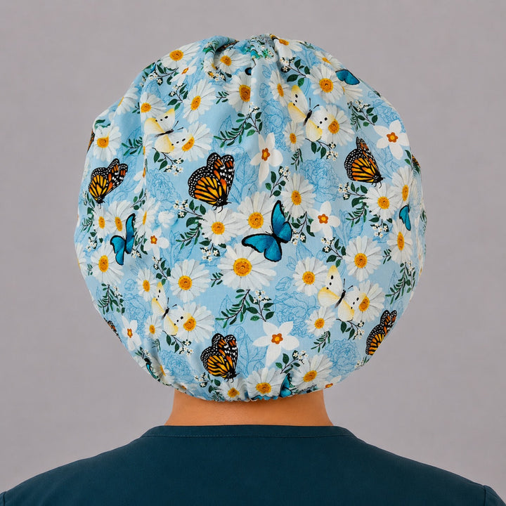 Back view of the spring butterfly daisy bouffant scrub cap showing the full roomy fit — monarch and blue butterflies over daisies