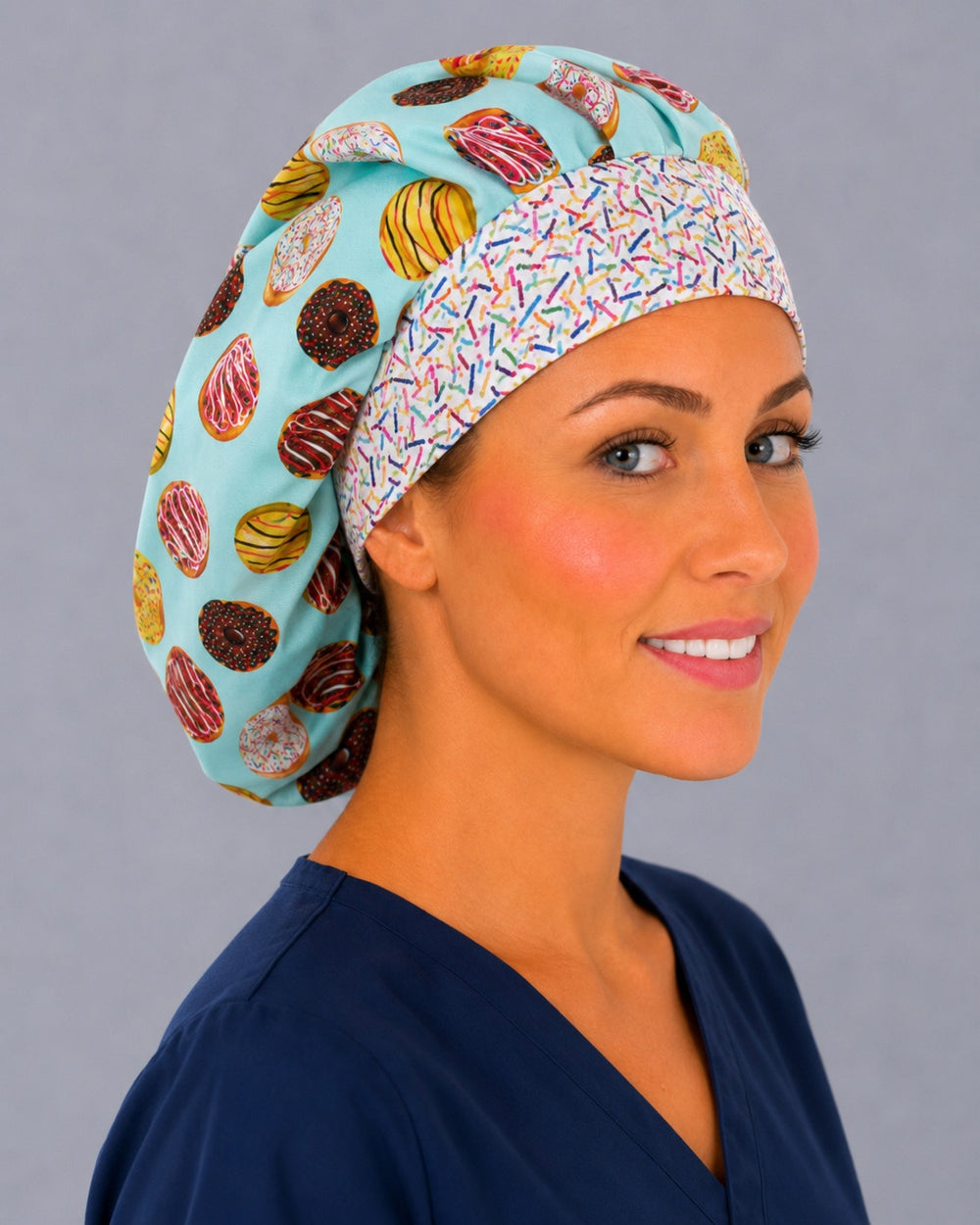 Sprinkle donut bouffant scrub cap, three-quarter smiling view on a vet tech — colorful doughnut print bouffant surgical hat, breathable cotton