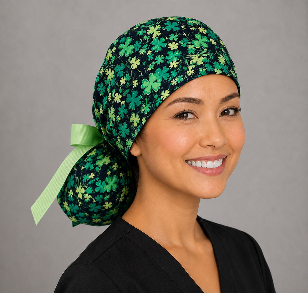 St. Patrick's glitter clovers ponytail nurse cap left three-quarter angle on smiling model showing green four-leaf clovers and glitter on black with lime green ribbon bow