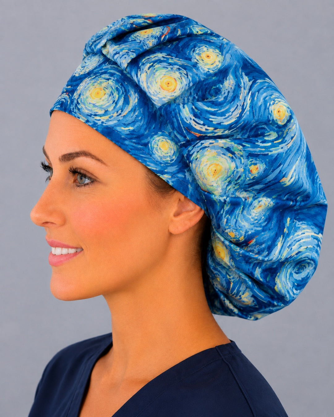 Woman wearing a Starry Night bouffant scrub cap, front view — Van Gogh-inspired blue swirls and golden stars, adjustable women&