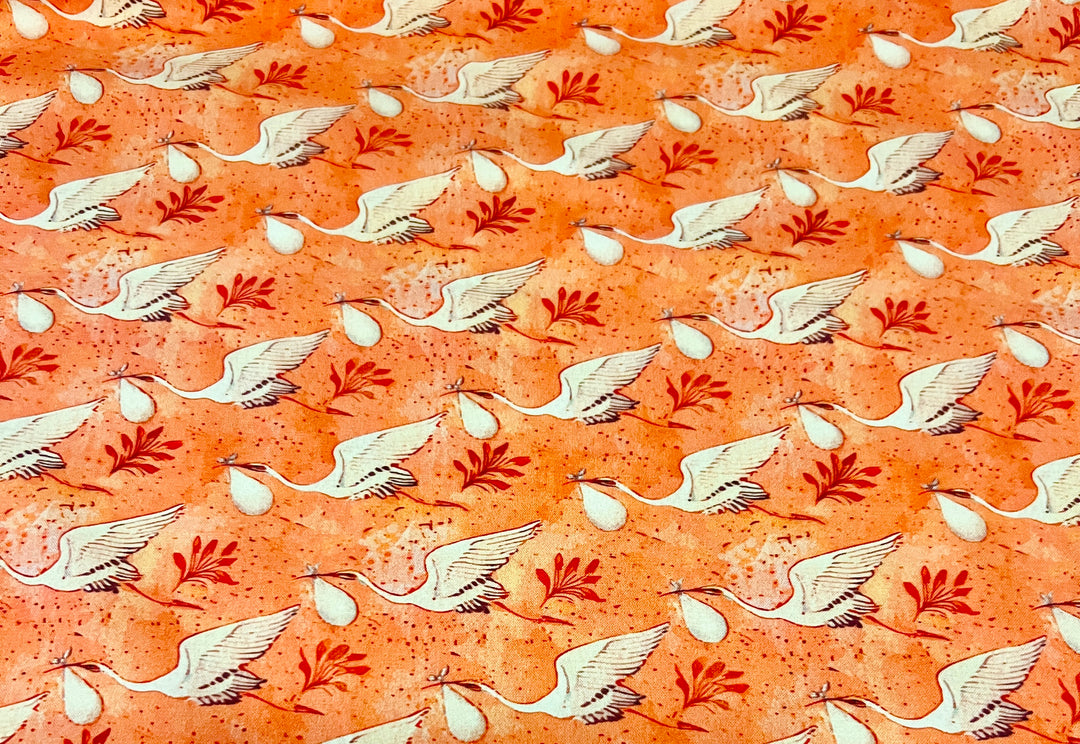 Close-up of coral stork and crane fabric print for L&amp;D ponytail scrub cap, white storks carrying baby bundles, OR World