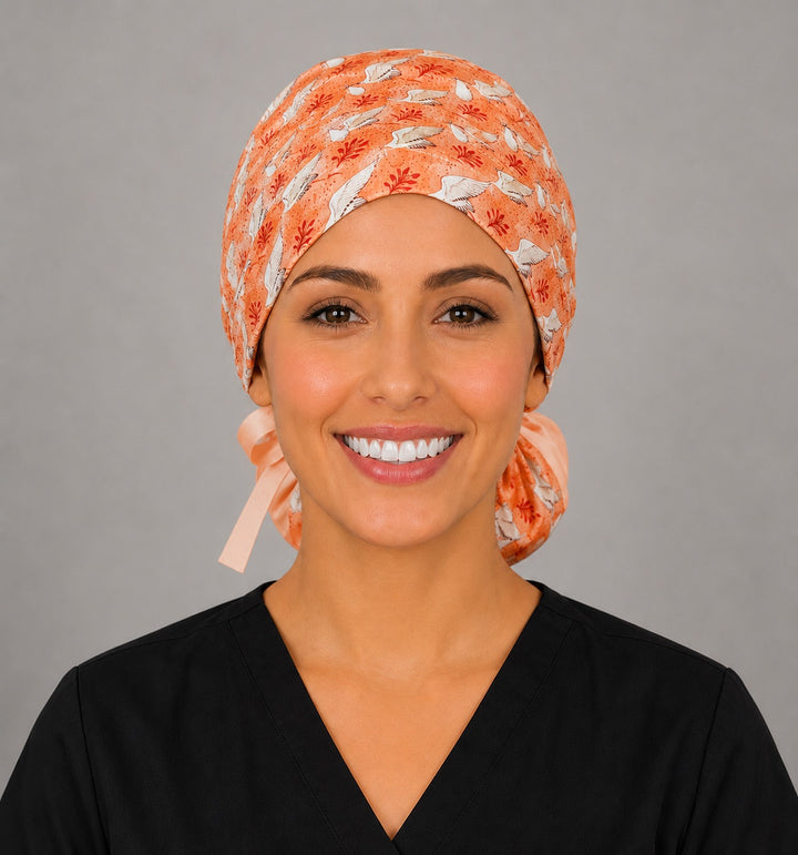 Front view of coral stork ponytail scrub cap on L&amp;D nurse, labor and delivery surgical hat for women, handmade USA, OR World