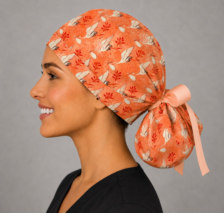 Side view of stork ponytail scrub cap showing back pouch for long hair, coral crane print GYN and OB surgical hat, handmade USA, OR World