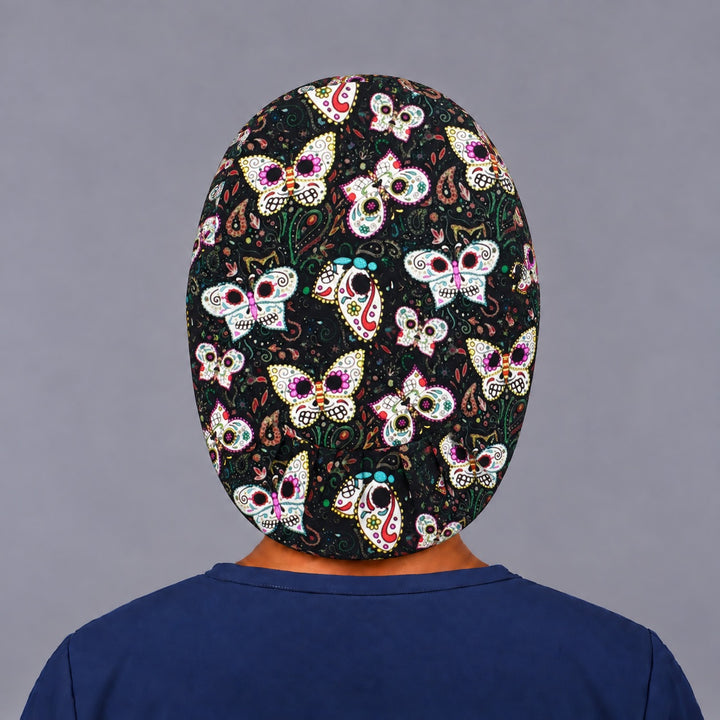 Back view of the sugar skull butterfly Euro scrub cap — elastic gathered back showing painted skull butterflies across the black crown