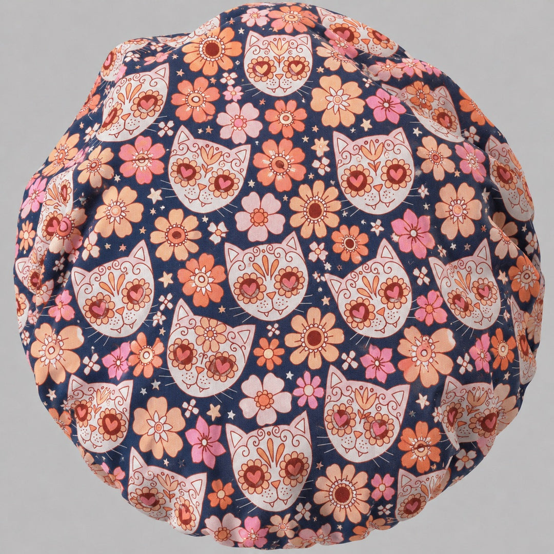 Back view of the sugar skull cat bouffant scrub cap — full gathered fit showing calavera cats and floral print across the navy crown