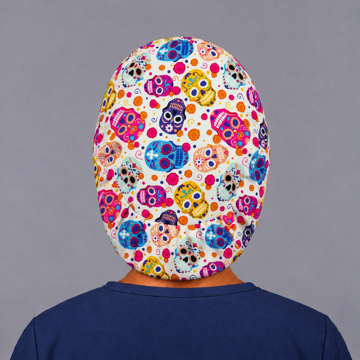 Back view of the sugar skull euro cap, showing the oval crown panel of colorful calaveras and the elastic gather hugging the base of the head