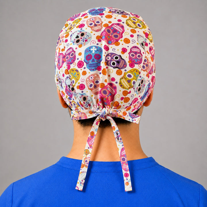 Colorful sugar skull scrub cap for short hair, handmade Day of the Dead tie-back surgical hat on OR nurse, front view