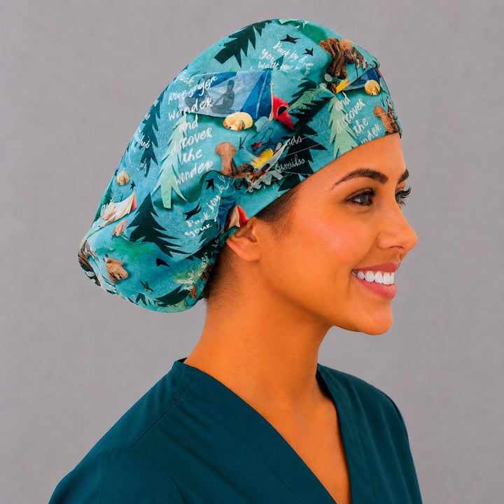 Summer camping bouffant surgical cap left three-quarter angle on smiling model showing teal camping print with campers, tents and forest critters, OR World nurse hat