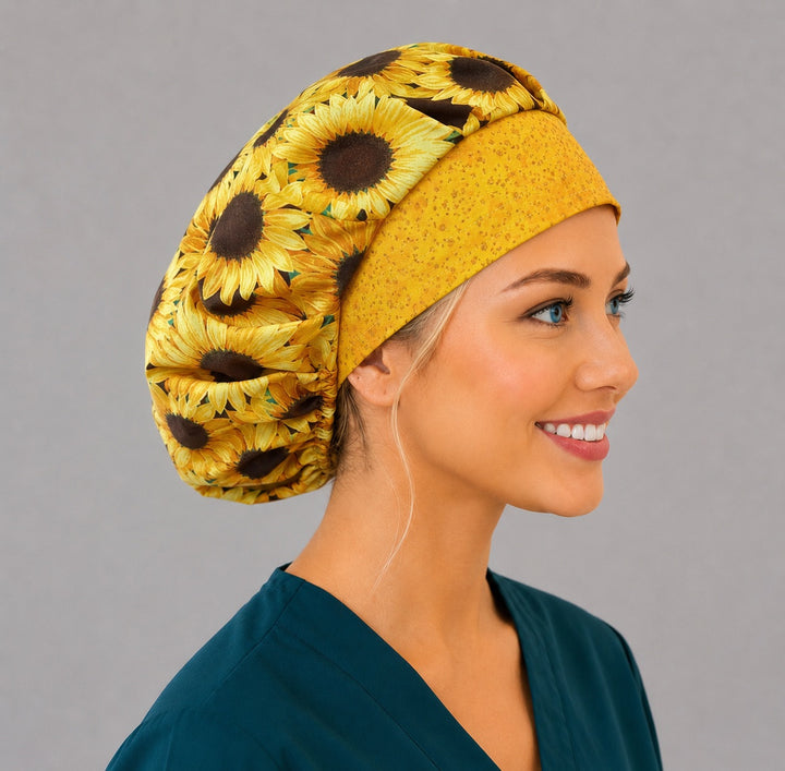 Sunflower bouffant scrub cap left three-quarter angle on smiling model showing golden sunflowers with yellow front band, women&