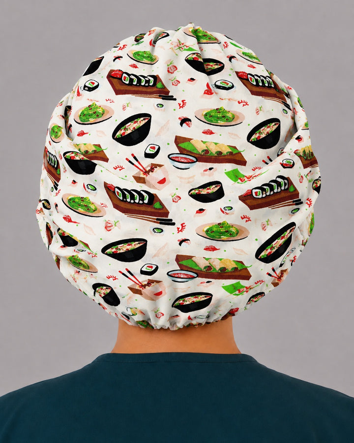 Back view of the sushi bouffant scrub cap — full gathered coverage showing maki rolls, sashimi and ramen bowls across the crown
